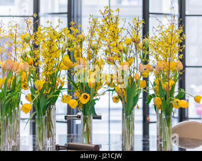 gorgeous yellow flowers in glass vases in a London Hotel lobby Stock Photo