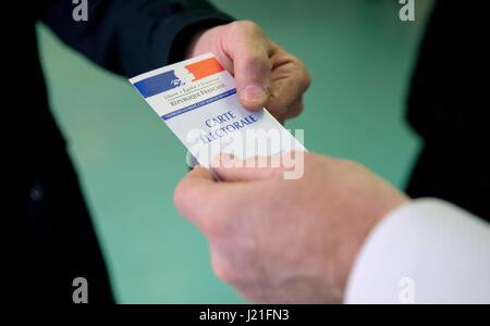 Henin-Beaumont, France. 23rd Apr, 2017. The director of a polling station for the French presidential elections checks the voting card of a voter in Henin-Beaumont, France, 23 April 2017. A total of eleven candidates participates in the first round of the presidential elections. Photo: Kay Nietfeld/dpa/Alamy Live News Stock Photo