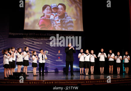 Budapest, Hungary. 23rd Apr, 2017. Movie star Jackie Chan (C) and students from the Hungarian-Chinese Bilingual Primary and Secondary School attend the opening ceremony of the 2017 Chinese Film Festival at the Urania National Film Theater in Budapest, Hungary, on April 23, 2017. The 2017 Chinese Film Festival started here on Sunday with the presence of world famous film star Jackie Chan and five movies, one of which is Jackie Chan's latest production 'Kung Fu Yoga'. Credit: Ye Pingfan/Xinhua/Alamy Live News Stock Photo