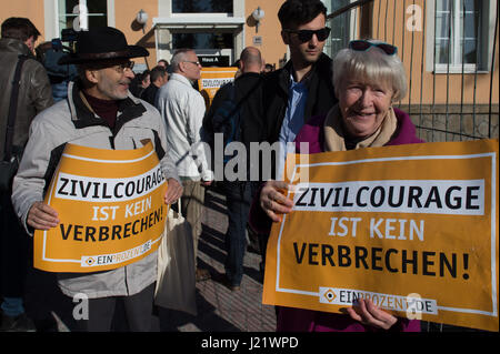 Kamenz, Germany. 24th Apr, 2017. Demonstrators hold up signs reading 'Civic courage is not a crime' in front of the district court in Kamenz, Germany, 24 April 2017. Almost a year after the four men forced a psychologically unsound refugee from a supermarket and tied him to a tree they are now standing trial at court. The defendants between the ages of 29 abd 56 are accused of deprivation of liberty. They all plead not guilty and state that the Iraqi man posed a threat to a female cashier at the supermarket in Arnsdorf. Photo: Arno Burgi/dpa-Zentralbild/dpa/Alamy Live News Stock Photo