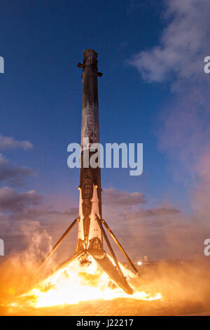 The SpaceX reused Falcon 9 first stage rocket successfully returns to earth to land on the ocean going droneship, 'Of Course I Still Love You' March 30, 2017 in the Atlantic Ocean. The reusable rocket landed perfectly after carrying the SES 10 communications satellite into space. Stock Photo