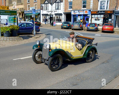 A man driving an early Austin Seven open top car with a dog in the passenger seat in North Yorkshire Stock Photo