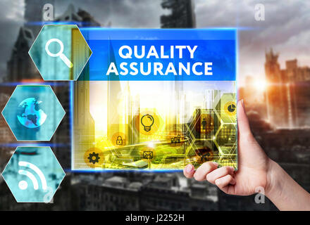 Technology, internet, business and marketing. Young business woman writing word: Quality assurance Stock Photo