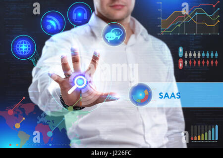 Business, Technology, Internet and network concept. Business man working on the tablet of the future, select on the virtual display: SAAS Stock Photo