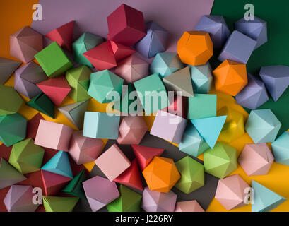 Colorful abstract geometric background with three-dimensional solid figures. Pyramid Dodecahedron prism rectangular cube arranged on colored paper. Stock Photo