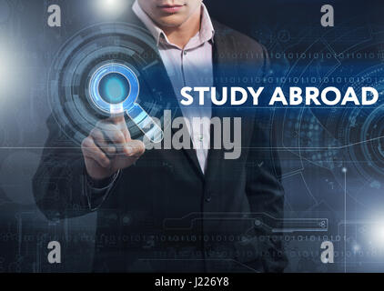 Business, Technology, Internet and network concept. Business man working on the tablet of the future, select on the virtual display: study abroad Stock Photo