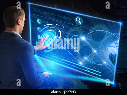 Businessman pressing high tech type of modern buttons on a virtual background Stock Photo