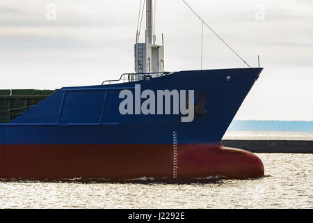 Blue cargo ship's bow leaving the port of Riga Stock Photo