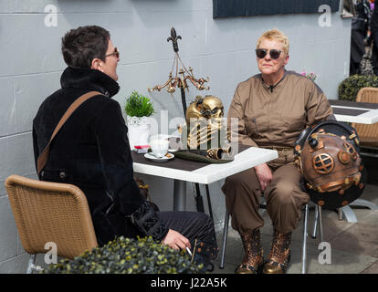 Two female Steampunks sat at a table having a drink and a smoke at Whitby Goth Weekend in North Yorkshire,England,UK Stock Photo