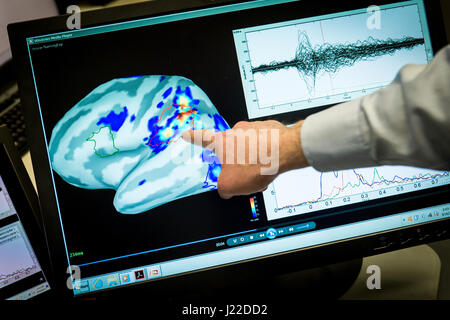 Magnetoencephalography (MEG) Laboratory scientist, Mihai Popescu points out areas of magnetic activity in a brain on a display at the National Intrepid Center of Excellence (NICoE) at Walter Reed National Military Medical Center in Bethesda, Md., Mar. 16, 2017. (U.S. Air Force photo by J.M. Eddins Jr.) Stock Photo