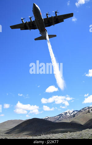 A C130h aircraft loaded with the MAFFS (Modular Airborne Fire Fighting System) from the 153rd Airlift Wing of Cheyenne, Wyoming drops a water line while training to contain wildfires just outside Bosie, Idaho. April 21, 2017. More than 400 personnel of four C-130 Guard and Reserve units — from California, Colorado, Nevada and Wyoming, making up the Air Expeditionary Group — are in Boise, Idaho for the week-long wildfire training and certification sponsored by the U.S. (U.S. Air National Guard photo by Staff Sgt. Nieko Carzis) Stock Photo