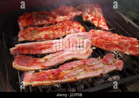 Closeup on pork chops being cooked in a coal barbecue. Stock Photo
