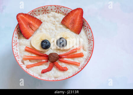 Oatmeal porridge with a kitten face decoration Stock Photo