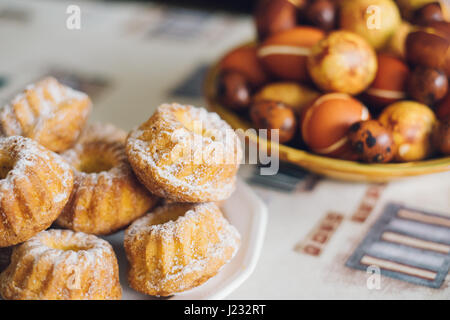 Holiday cakes and decorated Easter eggs on table, selective focus Stock Photo