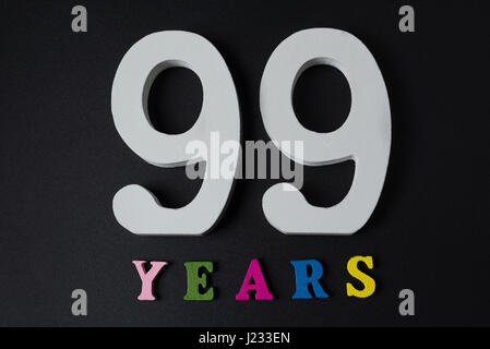 Letters and numbers ninety-nine years on a black isolated background. Stock Photo