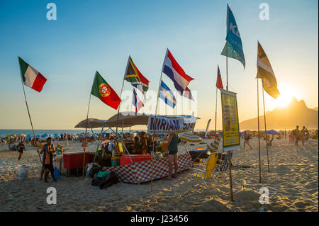 RIO DE JANEIRO - FEBRUARY 23, 2017: International flags fly over a beach 'barraca' tent reflecting the nationalities of the tourist customers. Stock Photo