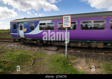 Train Passing a Pedestrian Crossing Warning Sign, Silverdale Lancashire, North West, England UK Stock Photo