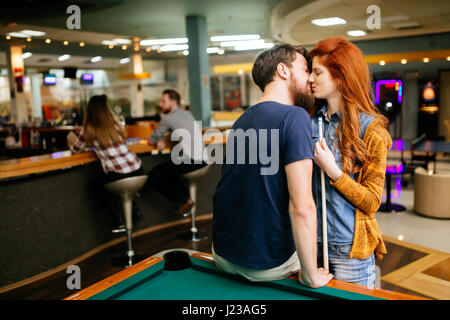Beautiful couple kissing in billiards bar on their date Stock Photo