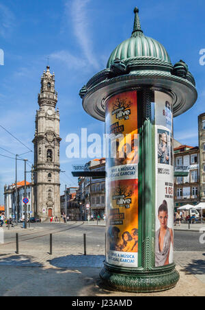 Portugal, Region Norte, Porto, Advertising column at Rua de Sao Filipe against the backdrop of the monumental 75.6 metre Baroque bell tower (Torre dos Stock Photo