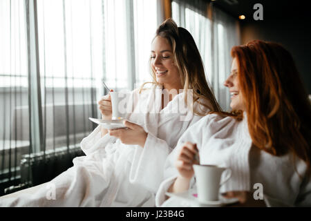 Women in bathrobes enjoying tea during wellness weekend Stock Photo