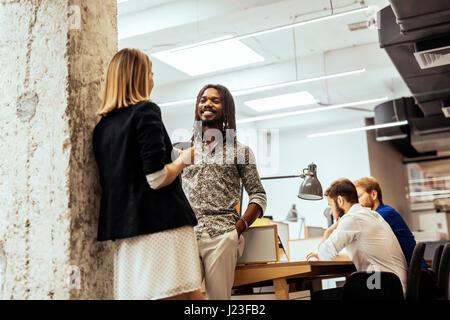 Business colleagues talking in the office  and smiling Stock Photo