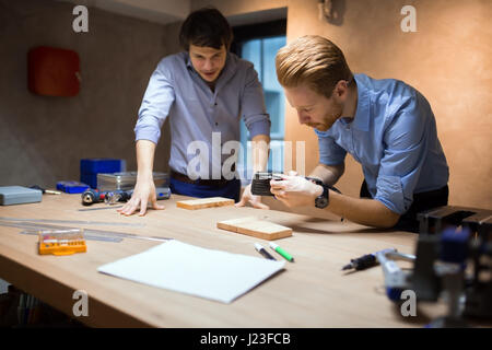 Two designers working together in workshop with precision tools Stock Photo