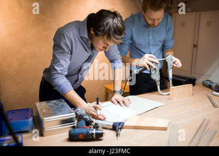 Two designers working together in workshop with precision tools Stock Photo