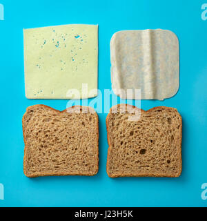 high-angle shot of the ingredients to prepare a ham and cheese sandwich, a pair of slices of brown bread, a slice of ham and a slice of cheese on a bl Stock Photo