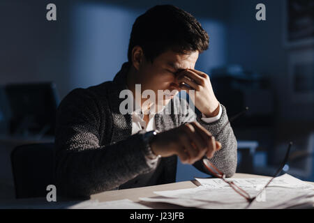 Stressed businessman sitting in office in late evening Stock Photo