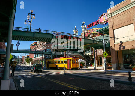 TAMPA, FLORIDA, US - November 29, 2003: Footbridges to Centro Ybor entrance with yellow tram underneath and visiting tourists, Tampa, FL Stock Photo