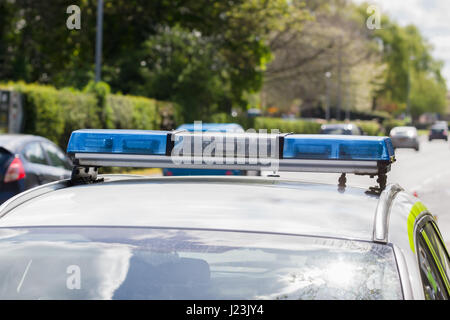 Light bars on unidentified British police vehicle monitoring traffic on a busy main road or highway with defocussed traffic in the background Stock Photo