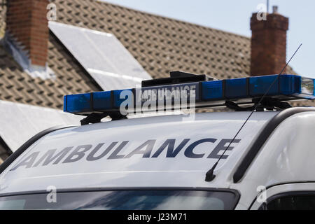 Light bars on unidentified British ambulance attending a medical emergency outside a house Stock Photo