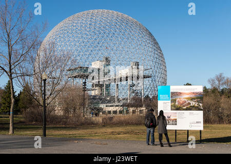 Montreal, CA - 13th April 2017: Woman looking at the sign presenting Jean Drapeau park redevelopment project Stock Photo