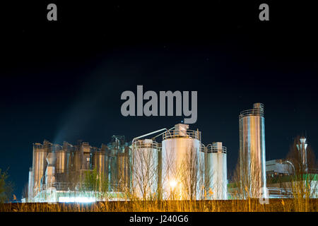 Illuminated Storage tanks of a chemical plant at night Stock Photo