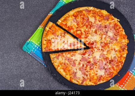 Pizza with ham and cheese on black stone Studio Photo Stock Photo