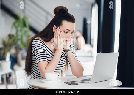 Disappointed businesswoman looking at business results on laptop screen in the office. Stock Photo