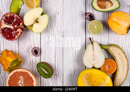 Fresh ripe halved fruits. Composition on a wooden light background. Stock Photo