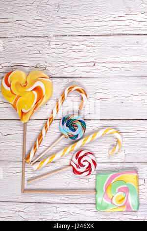 Multi-coloured lollypops on a wooden board Stock Photo