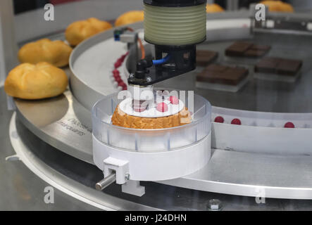 Hanover, Germany. 24th Apr, 2017. A robot decorates cookies during the Hanover Messe 2017 in Hanover, Germany, on April 24, 2017. The Hanover Messe started on Monday, and will last until April 28. More than 6,500 exhibitors from 70 nations and regions are presenting technologies for tomorrow's factories and energy systems in an action-packed industrial technology showcase themed 'Integrated Industry -- Creating Value'. Credit: Shan Yuqi/Xinhua/Alamy Live News Stock Photo