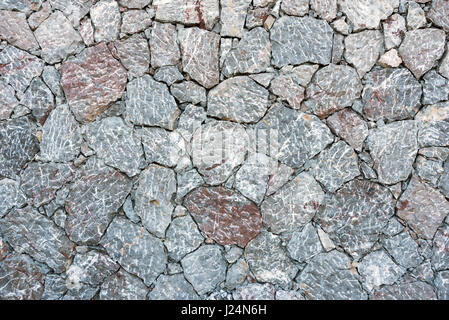 Background from a rough gray natural stone wall Stock Photo
