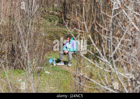 MILAN, ITALY - JULY 12, 2016: homeless man on the bench in the Bronx park after fighting for life. Stock Photo