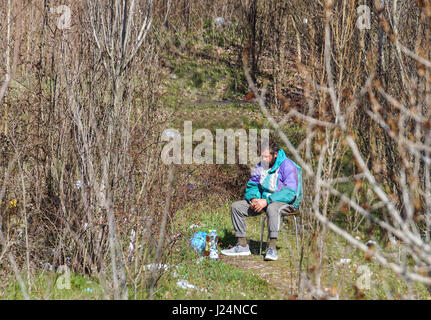 MILAN, ITALY - JULY 12, 2016: homeless man on the bench in the Bronx park after fighting for life. Stock Photo