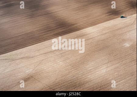 AERIAL VIEW of agriculture crops and farmland ploughed by tractor Stock Photo