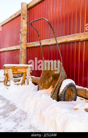 Old wheelbarrow with snow at village of Goloustnoye, Russia Stock Photo