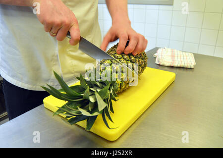 Cook cutting a pineapple Stock Photo