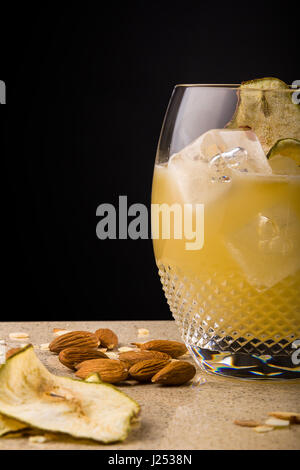 Tequila shaken with pear juice, agave, fresh lime and almond. Served in a martini glass and garnished with toasted almonds & fresh pear Stock Photo