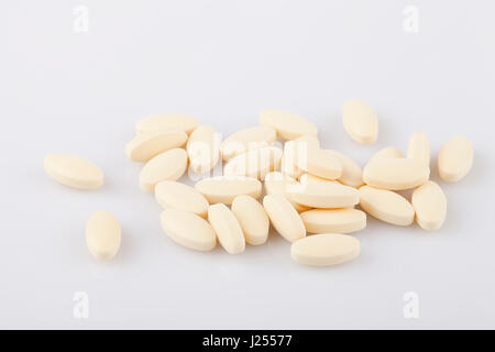 Yellow pills on a white surface. Pills isolated on white background. Stock Photo