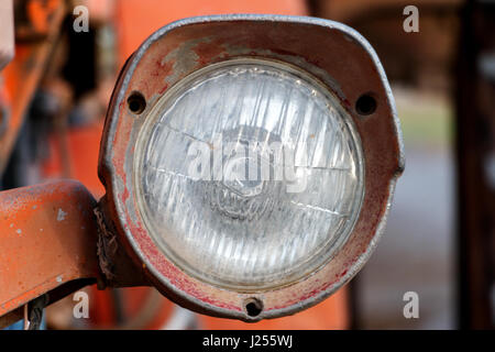 A close up of a headlight of an old rusty tractor Stock Photo