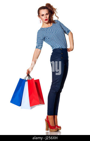 Shopping. The French way. Full length portrait of cheerful trendy woman with shopping bags of the colours of the French flag isolated on white backgro Stock Photo
