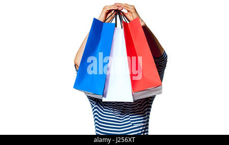 Shopping. The French way. Full length portrait of young fashion-monger holding in the front of head shopping bags of the colours of the French flag is Stock Photo